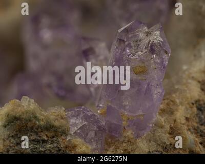 Isolierte und violette Kristalle aus Amethyst-Quarz auf Matrix Stockfoto