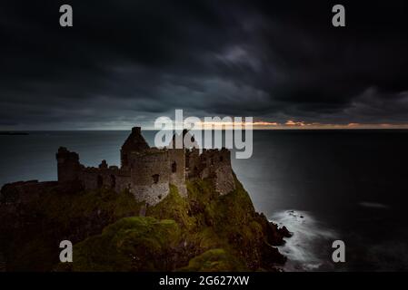 Dunluce Burg an einem bewölkten Abend Stockfoto