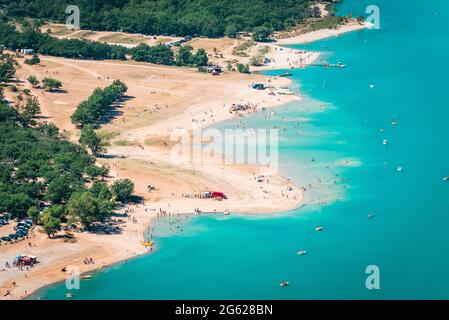 Strand und Badegäste am Ufer eines türkisfarbenen Sees Stockfoto