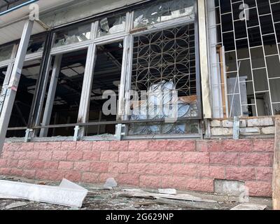 Nahaufnahme von kaputten Fenstern im alten Gebäude. Fenster mit kaputten Gläsern in verlassenen Backsteingebäude. Konzept der Straßenunruhen Stockfoto