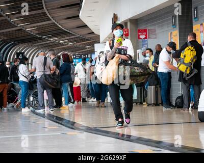 Medellin, Antioquia, Kolumbien - 17 2021. Mai: Latina mit Maske geht mit ihren Taschen am Flughafen Jose Maria Cordova Terminal Stockfoto