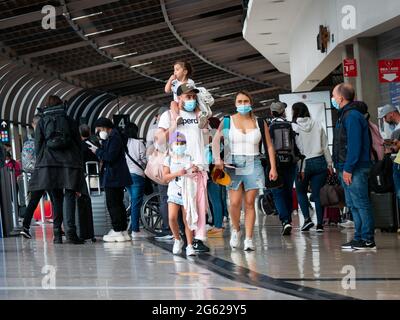 Medellin, Antioquia, Kolumbien - Mai 17 2021: Lateinische Familie mit Maske geht mit ihren Taschen am Jose Maria Cordova Flughafenterminal spazieren Stockfoto