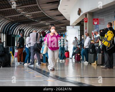 Medellin, Antioquia, Kolumbien - 17 2021. Mai: Lateinische Alte mit Maske geht mit ihren Taschen am Flughafen Jose Maria Cordova Terminal Stockfoto