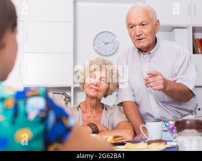 Ernsthafte ältere Eltern, die unangenehme Gespräche mit ihrer Tochter führen Stockfoto