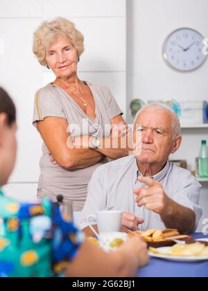 Ernsthafte ältere Eltern, die unangenehme Gespräche mit ihrer Tochter führen Stockfoto