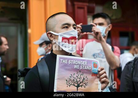 Ein Protestler, der eine Gesichtsmaske mit einer aufgedruckten chinesischen Flagge trägt, nimmt an der Demonstration Teil. Hongkongers veranstaltete Demonstrationen in zehn verschiedenen Städten in Großbritannien, um gegen den einjährigen Jahrestag der Promulgation des Hongkonger nationalen Sicherheitsgesetzes und den hundertjährigen Jahrestag der Kommunistischen Partei Chinas zu protestieren. In London versammelten sich die Teilnehmer vor der chinesischen Botschaft und marschierten nach Chinatown, wo die Hauptereignis stattfand. Die Massen zogen später zum Wirtschafts- und Handelsbüro von Hongkong und vergaßen rauchige Fackeln draußen als symbolisches Zeichen der Verfluchtung der Regierung von Hongkong Stockfoto