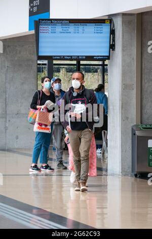 Medellin, Antioquia, Kolumbien - Mai 17 2021: Latein mit Maske geht mit ihren Taschen am Flughafen Jose Maria Cordova Terminal Stockfoto