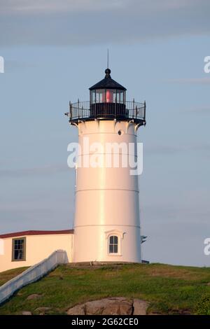 York, Maine, USA, 16. Juli 2019: Der ikonische Nubble Lighthouse von Southen Maine leuchtet, wenn der Tag beginnt und es in die Nacht übergeht. Stockfoto