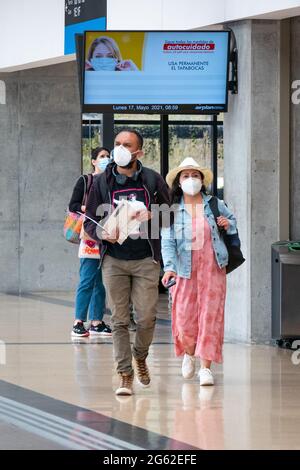 Medellin, Antioquia, Kolumbien - Mai 17 2021: Latein mit Maske geht mit ihren Taschen am Flughafen Jose Maria Cordova Terminal Stockfoto