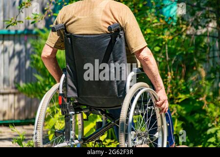Behinderte ältere Mann in den Vorsitz in der Landschaft Cottage, Elder Krankheit Stockfoto