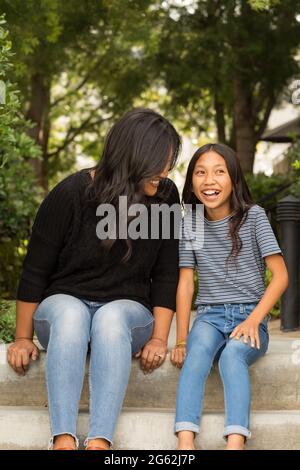 Asiatische Mutter lächelt und umarmt ihre Tochter. Stockfoto