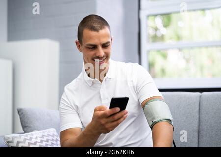 Blutdruckmessung Mit Dem Smart Monitor. Patient Man Stockfoto