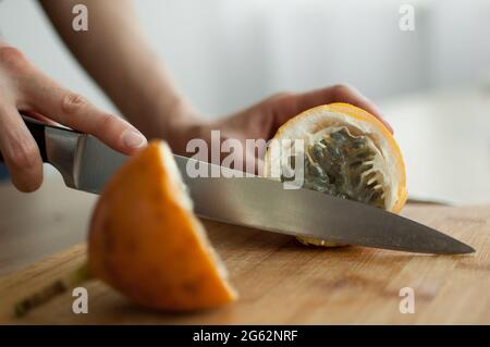 Frische, reife Bio-Granadilla oder gelbe Passionsfrucht, halbiert auf einem Holzbrett. Exotische Früchte, gesunde Ernährung Konzept Stockfoto