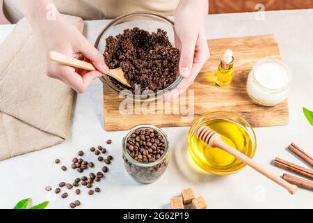 Frau, die Zutaten für die Zubereitung von Kaffee-Peeling oder Maske für die Hautbehandlung mischt Stockfoto