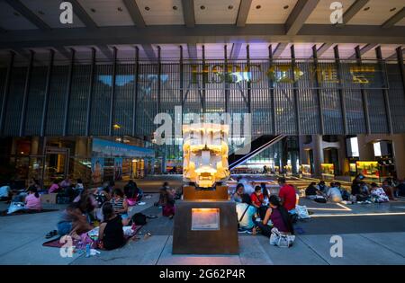 Haushelfer versammeln sich während ihres Urlaubs um die berühmten Löwen vor der HSBC Bank, dem Central Financial District, Hongkong, China. Stockfoto