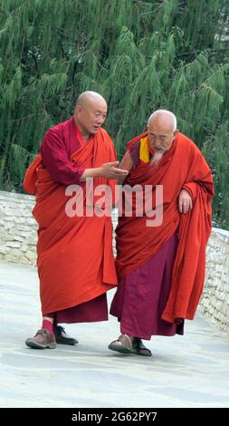 Zwei ältere buddhistische Mönche in Bhutan, die einen Pfad entlang gehen. Stockfoto