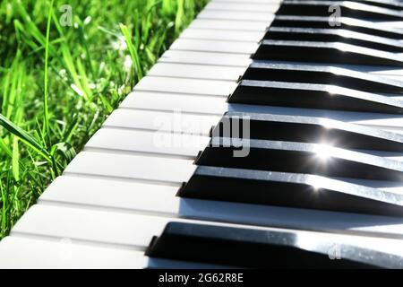 Klaviertastatur Nahaufnahme auf dem grünen Gras mit einem Sonnenlicht Stockfoto