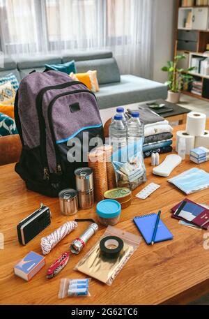 Notfallrucksack-Ausrüstung auf dem Tisch organisiert Stockfoto