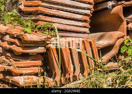 Ein Haufen alter Fliesen, vom Dach des Hauses entfernt. Stockfoto