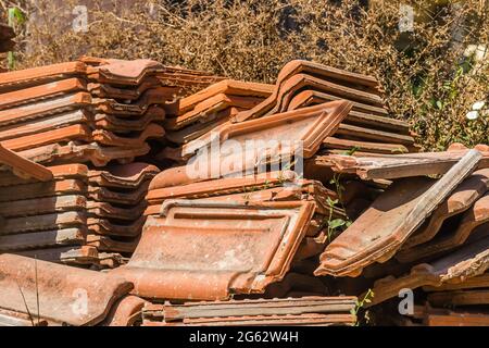 Ein Haufen alter Fliesen, vom Dach des Hauses entfernt. Stockfoto