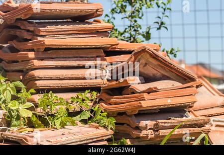 Ein Haufen alter Fliesen, vom Dach des Hauses entfernt. Stockfoto