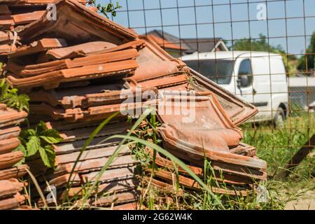 Ein Haufen alter Fliesen, vom Dach des Hauses entfernt. Stockfoto