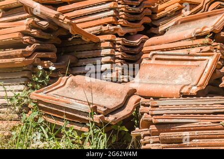 Ein Haufen alter Fliesen, vom Dach des Hauses entfernt. Stockfoto