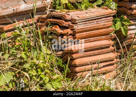 Ein Haufen alter Fliesen, vom Dach des Hauses entfernt. Stockfoto