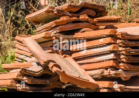 Ein Haufen alter Fliesen, vom Dach des Hauses entfernt. Stockfoto