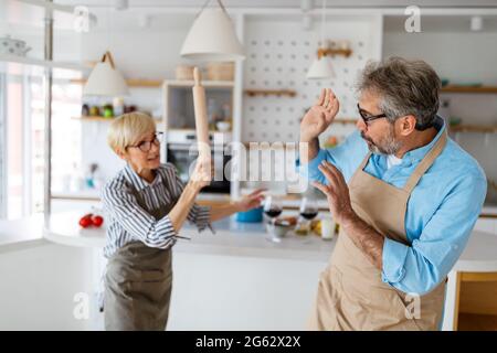 Familienstreit. Verärgert, verängstigt Senior Mann gegen wütende Frau zu Hause Stockfoto