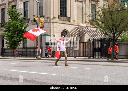 Ottawa, Kanada - 1. Juli 2021: Kanada-Tag in Ottawa Kanada in der Innenstadt. Mann winkt mit kanadischen Fahnen auf der Straße Stockfoto