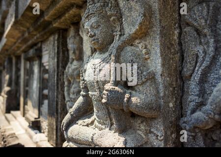 Nahaufnahme eines steinernen Flachreliefs an der Wand, der einen gott im alten Prambanan-Tempel in Yogyakarta, Indonesien darstellt. Keine Personen. Stockfoto