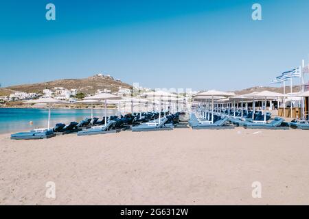 Ornos Strand Mykonos Insel, berühmter Ornos Strand organisiert mit Sonnenliegen smaragdklares Wasser Strand von Ornos auf der Insel Mykonos, Kykladen, Griechenland. Stockfoto