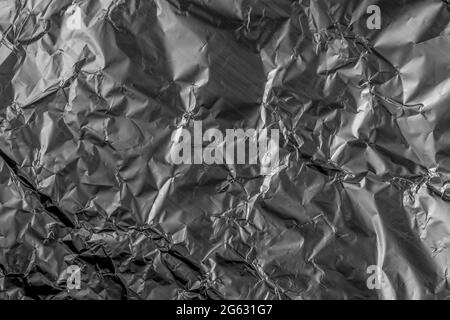 Zerkleinerte Textur aus zerknitterter Aluminiumfolie. Hintergrundabstraktion Stockfoto