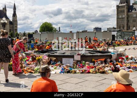 Ottawa, Kanada – 1. Juli 2021: Protest zum Canada Day absagen. Jedes Kind Zählt. Schuhe und Spielzeug, die in der Nähe der Centennial Flame auf dem Parliament Hill in MEM zurückgelassen wurden Stockfoto