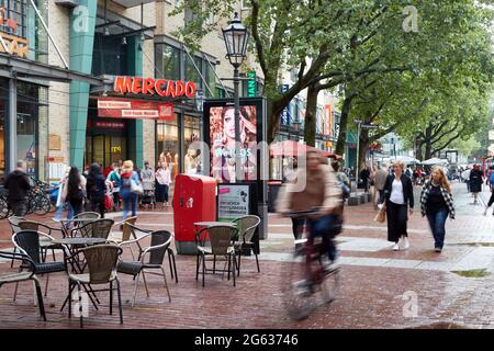 Hamburg, Deutschland. Juli 2021. Passanten laufen durch die Fußgängerzone in der Ottenser Hauptstraße am Eingang zum Einkaufszentrum Mercado vorbei. (Wischeffekt durch Langzeitbelichtung) Quelle: Georg Wendt/dpa/Alamy Live News Stockfoto
