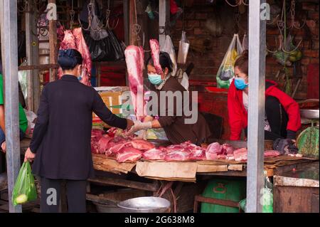 Kambodschanische Rohfleischverkäufern tragen während der Coronavirus-Pandemie Schutzmasken/Abdeckungen. Kandal Market, Phnom Penh, Kambodscha. März 2020. © Kraig Lieb Stockfoto
