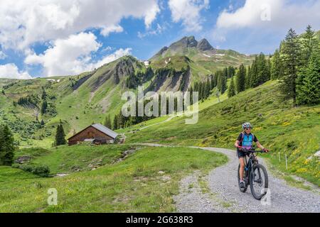 Glückliche ältere Frau auf ihrem elektrischen Berg unterhalb der Mittagsspitze in der Nähe des Dorfes Damuels im Bregenzerwald Berg Vorarlberg, EIN Stockfoto