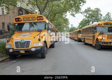 An einem Sonntagmorgen standen 2 lange Linien geparkter Schulbusse auf der Williamsburg Street East in Brooklyn. Sie stammen aus den Satmar Yeshiva-Pfarrschulen. Stockfoto