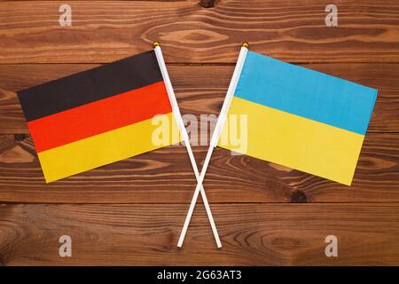 Die Flagge Deutschlands und die Flagge der Ukraine kreuzten sich miteinander. Das Bild veranschaulicht die Beziehung zwischen den Ländern. Fotografie für Nachrichten Stockfoto
