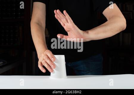 Nein zu Einweg-Kunststoff. Handgestensteuerung weist Einweg-Kunststoffbecher zurück. Kein Einweg-Kunststoff. Stockfoto