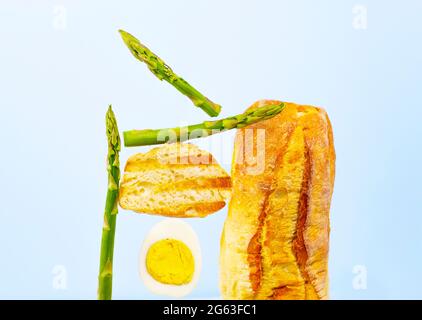 Frisches Brot, Spargel und Ei. Zum Frühstück gibt es Inridients. Gleichgewichtsschwimmende Lebensmittel. Balance Levitation Food. Gesunde Vitamin-Ernährung Stockfoto