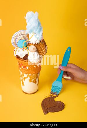 Schokoladen-Milchshake mit Marmeladen und Keksen verziert. Hand zeichnet ein Schokoladenherz Stockfoto