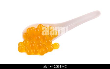 Gelbe Tapiokaperlen für Bubble Tea isoliert auf weißem Hintergrund. Tapioka-Perlen in Keramiklöffel Stockfoto