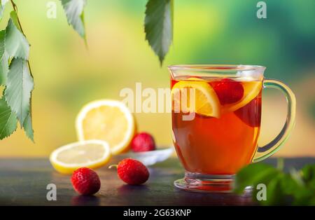 Frischer Tee mit Zitrone und Erdbeeren in einer großen Glasschale Stockfoto