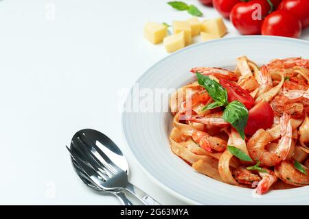 Teller mit Garnelen-Pasta und Zutaten auf weißem Hintergrund Stockfoto