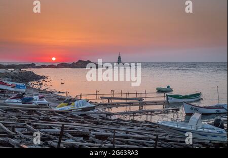 Ahtopol - 10. September: Sonnenaufgang am Strand mit Fischerpier, Felsen und Leuchtturm am 10. September 2016, Ahtopol, Bulgarien Stockfoto