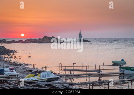 Ahtopol - 10. September: Sonnenaufgang am Strand mit Fischerpier, Felsen und Leuchtturm am 10. September 2016, Ahtopol, Bulgarien Stockfoto