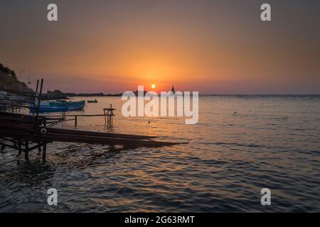 Ahtopol - 10. September: Sonnenaufgang am Strand mit Fischerpier, Felsen und Leuchtturm am 10. September 2016, Ahtopol, Bulgarien Stockfoto