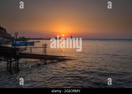 Ahtopol - 10. September: Sonnenaufgang am Strand mit Fischerpier, Felsen und Leuchtturm am 10. September 2016, Ahtopol, Bulgarien Stockfoto